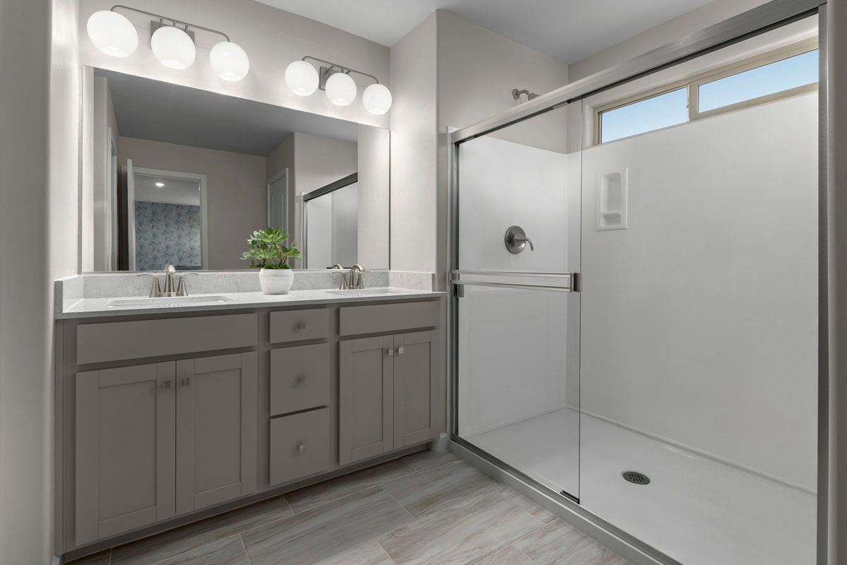 Upgraded walk-in shower with cultured marble surround at primary bath