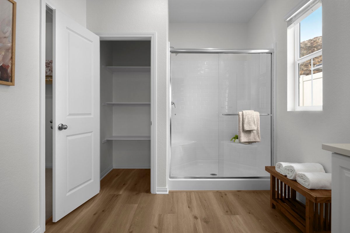 Walk-in shower and linen closet at primary bath