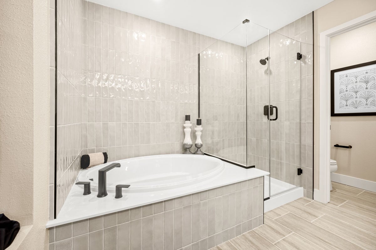 Tub and separate shower with custom tile surround at primary bath