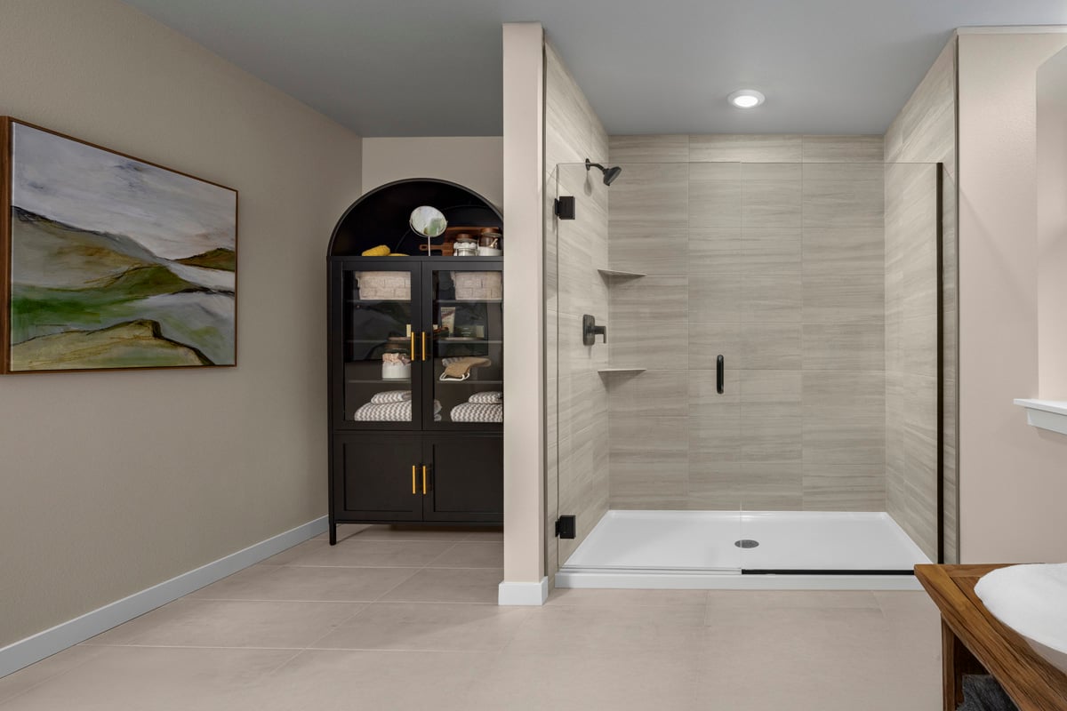 Walk-in shower with glass enclosure at primary bath
